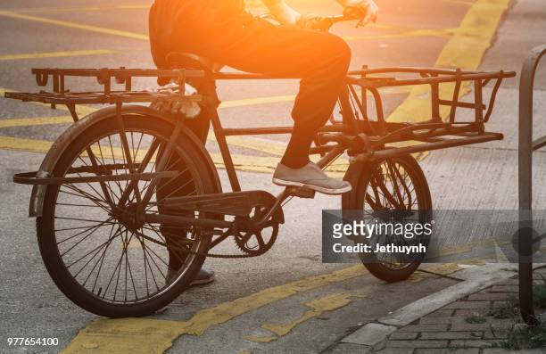 worker man ride a bicycle for transporting goods at hong kong - jethuynh stock pictures, royalty-free photos & images