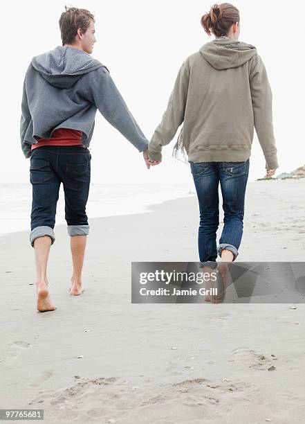 couple holding hands - jeans barefoot fotografías e imágenes de stock