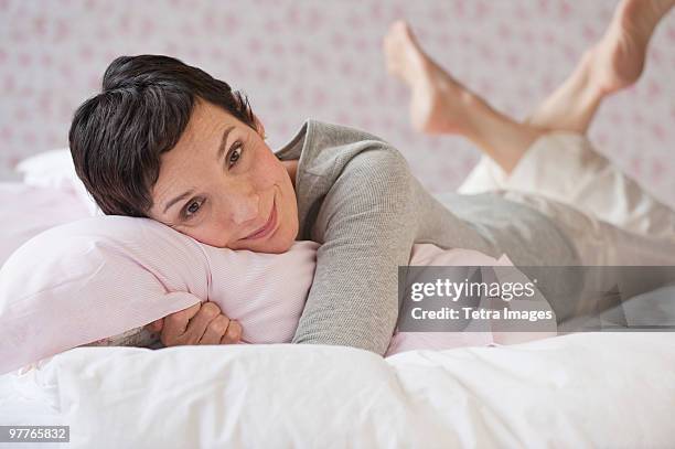 woman lying on bed - man and woman cuddling in bed stock-fotos und bilder