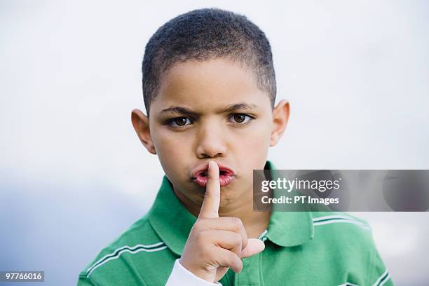 boy with finger in front of mouth - finger in mouth stockfoto's en -beelden