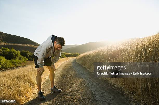 male jogger resting - sports pain foto e immagini stock