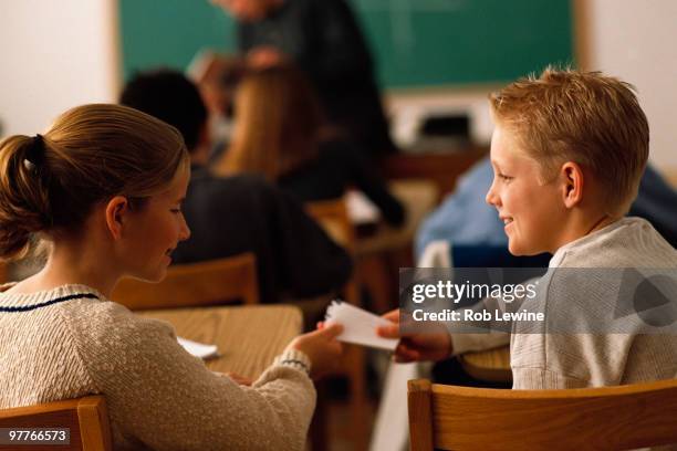 students passing note in classroom - kids passing notes stock pictures, royalty-free photos & images