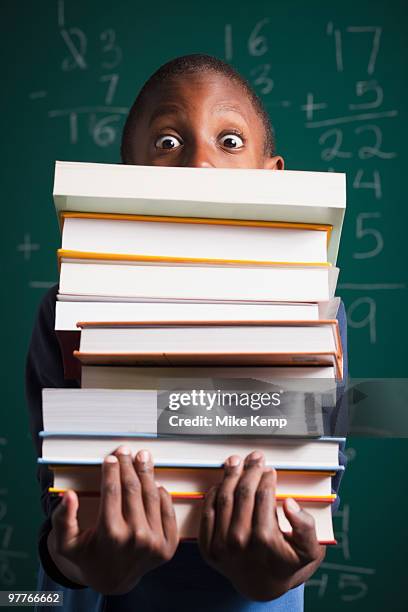 boy holding stack of books - text book stock pictures, royalty-free photos & images