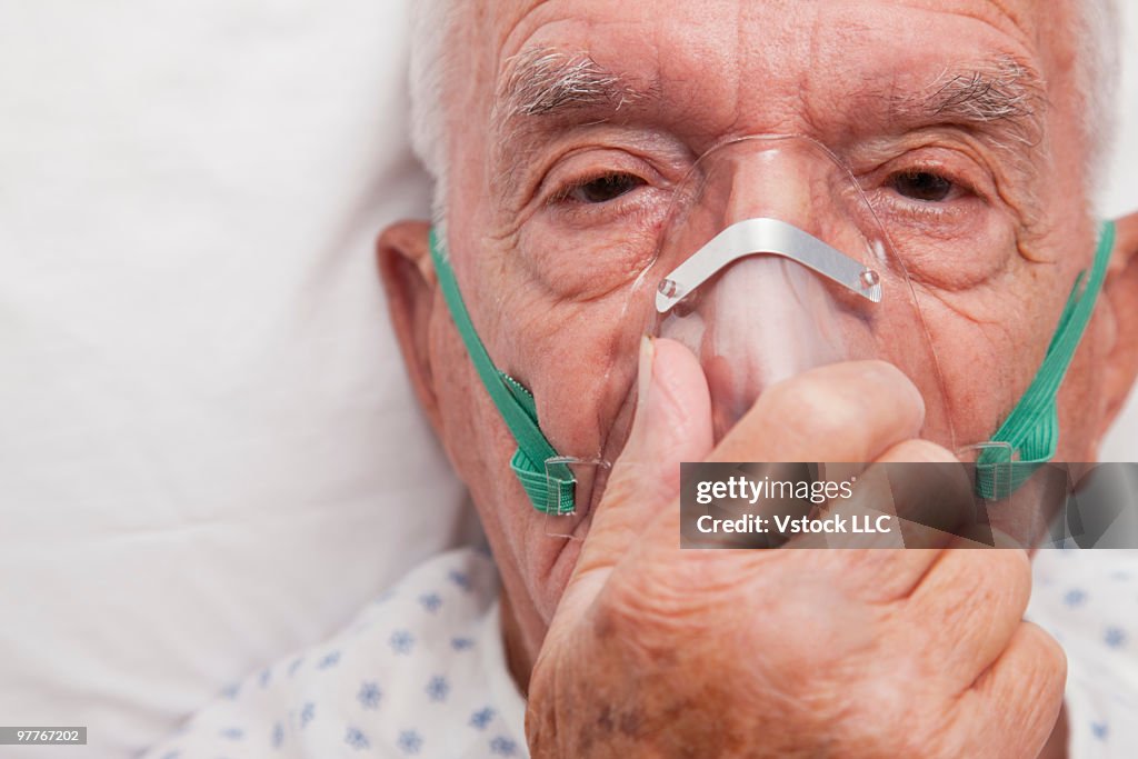 Elderly man wearing oxygen mask