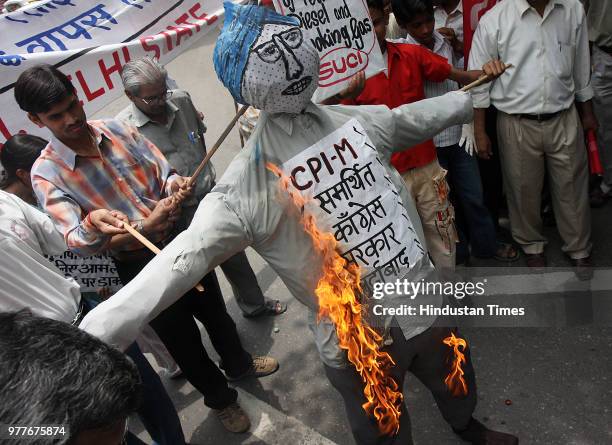 Leftist organisation shout slogans as they burn an effigy of central goverment during a protest against a hike of petroleum products, at Jantar...