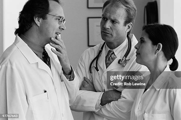 three doctors talking - black and white doctor stock pictures, royalty-free photos & images