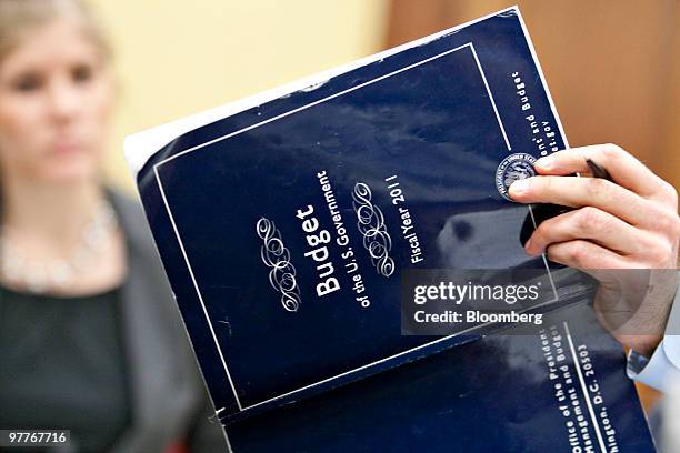 Peter Orszag, director of the U.S. Office of Management and Budget, shows an aide a U.S. Government budget book during a House Appropriations...