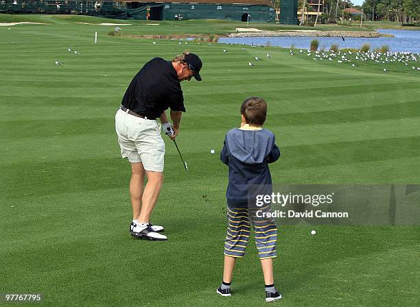 Ernie Els of South Africa watched by his son Ben during the Els for Autism Pro-Am on the Champions Course at the PGA National Golf Club on March 15,...