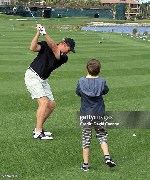 Ernie Els of South Africa watched by his son Ben during the Els for Autism Pro-Am on the Champions Course at the PGA National Golf Club on March 15,...