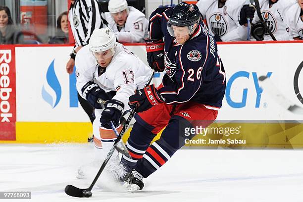 Samuel Pahlsson of the Columbus Blue Jackets and Andrew Cogliano of the Edmonton Oilers battle for control of the puck during the first period on...