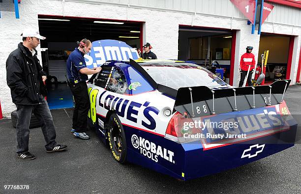 Crew chief Chad Knaus looks at the Lowes Chevrolet, driven by Jimmie Johnson, as crew members work on it in the garage area during testing for the...