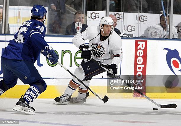 Aaron Johnson of the Edmonton Oilers skates up the ice against Toronto Maple Leafs' Tomas Kaberle during game action against theToronto Maple Leafs...