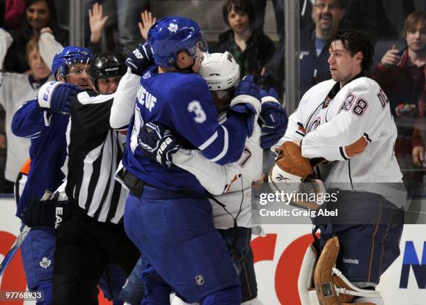 Dion Phaneuf of the Toronto Maple Leafs fights with Tom Gilbert of the Edmonton Oilers during game action March 13, 2010 at the Air Canada Centre in...