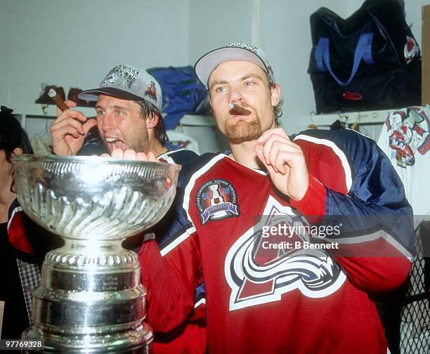 Curtis Leschyshyn and Warren Rychel of the Colorado Avalanche celebrate with the Stanley Cup in their locker room after their victory over the...