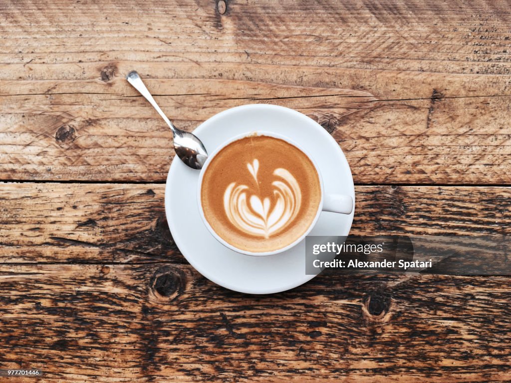 Cup of cappuccino with latte art, directly above view
