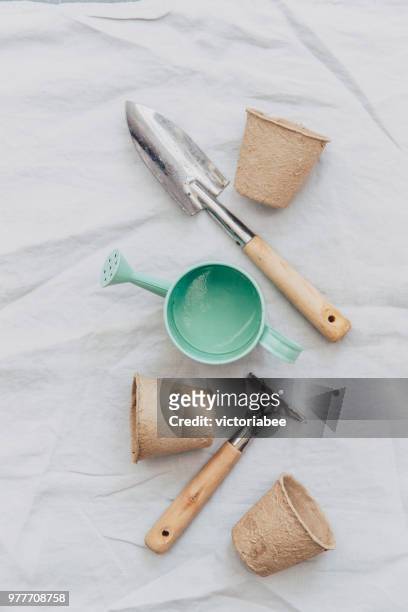 watering can, gardening tools and flower pots on linen tablecloth - gardening equipment white background stock pictures, royalty-free photos & images