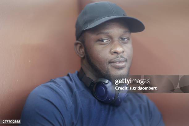 portrait of a man wearing a baseball cap and headphones around his neck - headphone man on neck stock pictures, royalty-free photos & images