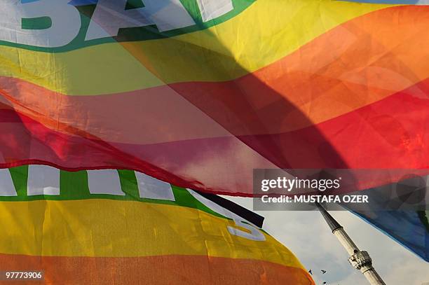 Turkish gay rights group activists wave peace flags infront of a mosque in Istanbul on March 16, 2010 during a demonstration against Family Affairs...