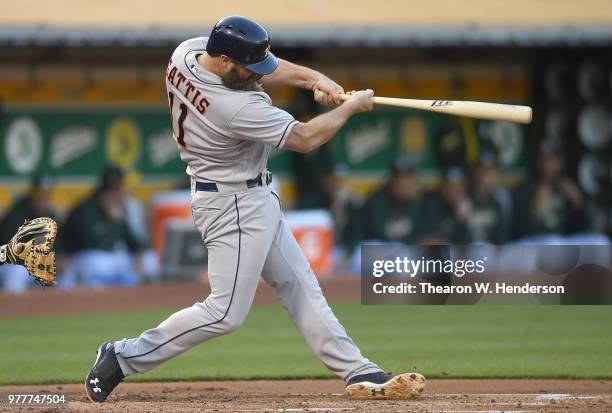 Evan Gattis of the Houston Astros hits a three-run home run against the Oakland Athletics in the top of the second inning at the Oakland Alameda...