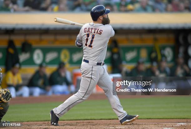 Evan Gattis of the Houston Astros hits a three-run home run against the Oakland Athletics in the top of the second inning at the Oakland Alameda...