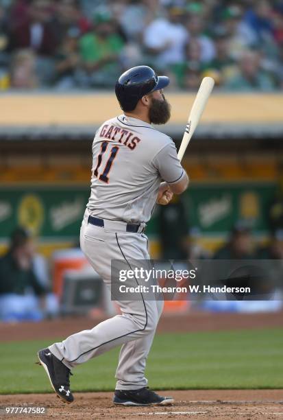 Evan Gattis of the Houston Astros hits a three-run home run against the Oakland Athletics in the top of the second inning at the Oakland Alameda...