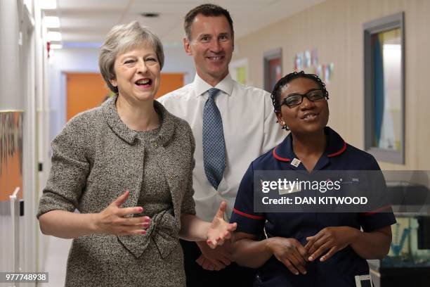 Britain's Prime Minister Theresa May and Britain's Health and Social Care Secretary Jeremy Hunt meet nursing staff during their visit to the Royal...