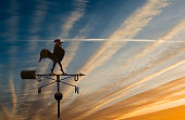 Silhouette of weather vane with decorative metallic rooster