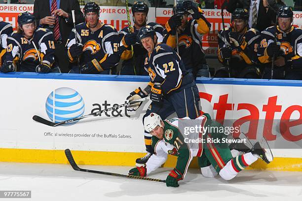 Adam Mair of the Buffalo Sabres trips up Kyle Brodziak of the Minnesota Wild at HSBC Arena on March 12, 2010 in Buffalo, New York.