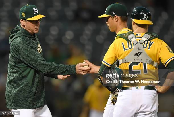 Manager Bob Melvin of the Oakland Athletics takes the ball from starting pitcher Daniel Mengden taking Mengden out of the game against the Houston...