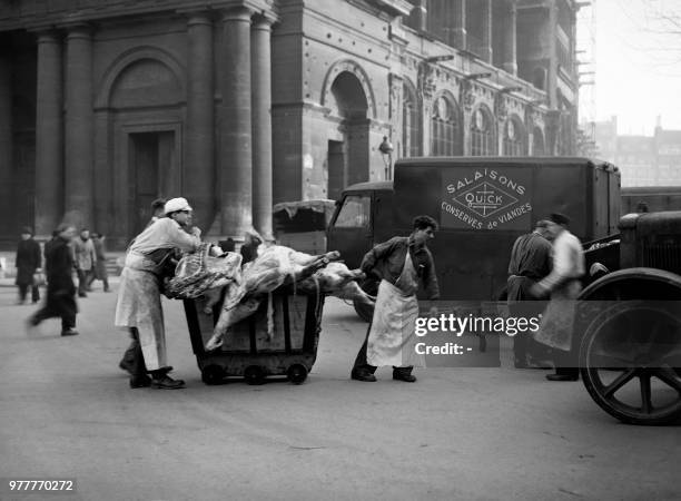 Workers of a butcher's shop carry meat in Les Halles district in January 1946 in Paris during the meat strike. .