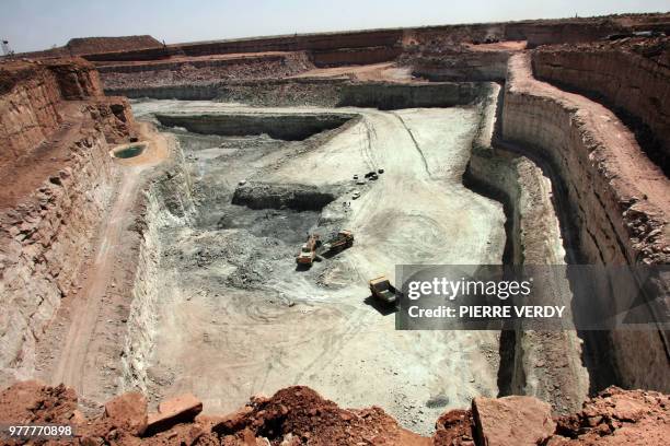 Trucks carry rocks containing uranium 23 February 2005 at Arlit opencast mine in the Air desert, one of the world's most impoverished regions. At the...