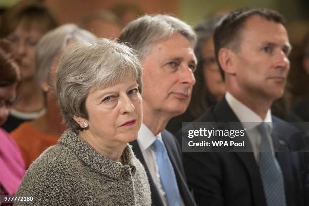 Prime Minister Theresa May looks on as she sits with Chancellor of the Exchequer Philip Hammond and Health Secretary Jeremy Hunt following her visit...