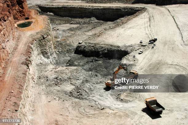 Trucks carry rocks containing uranium 23 February 2005 at Arlit opencast mine in the Air desert, one of the world's most impoverished regions. At the...