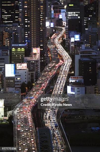 Photo taken from a Kyodo News helicopter on June 18 shows traffic congestion continuing after sunset in Osaka following a powerful earthquake that...