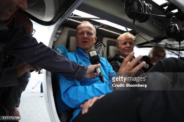 Ketil Solvik-Olsen, Norway's transport minister, left, speaks to a journalist as he sits in the cockpit of an Avinor AS Alpha Electro G2 electric...