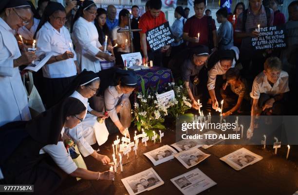 Australian nun Sister Patricia Fox , holds a candle along with colleagues as she attends a prayer vigil for the killed catholic priests in front of...
