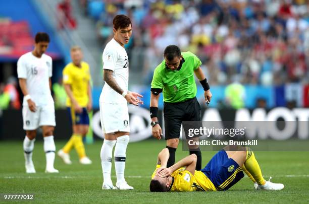 Jang Hyun-Soo of Korea Republic and Referee Joel Aguilar check on codition of Marcus Berg of Sweden as he lies injured during the 2018 FIFA World Cup...