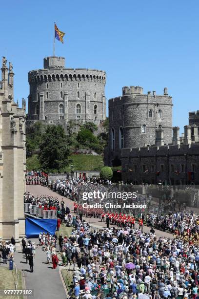 Guards of the Blues and Royals regiment and the military band march around the crowds waiting for Royal family and The Knights of the Garter to...