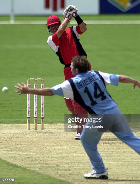 Bowler Shawn Bradstreet stretches but cannot stop a shot from Greg Blewett going for 4 in the Mercantile Mutual Cup match between South Australia and...