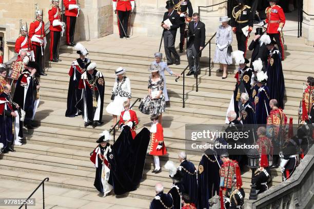 Guards, military, other members of the Royal family and The Knights of the Garter look on as Queen Elizabeth II walks down the steps to her carriage...