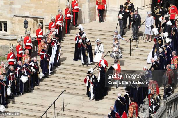 Guards, military, other members of the Royal family and The Knights of the Garter look on as Queen Elizabeth II walks down the steps to her carriage...