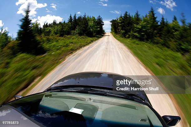 rooftop view of a car speeding down a gravel road. - monongahela national forest stock-fotos und bilder