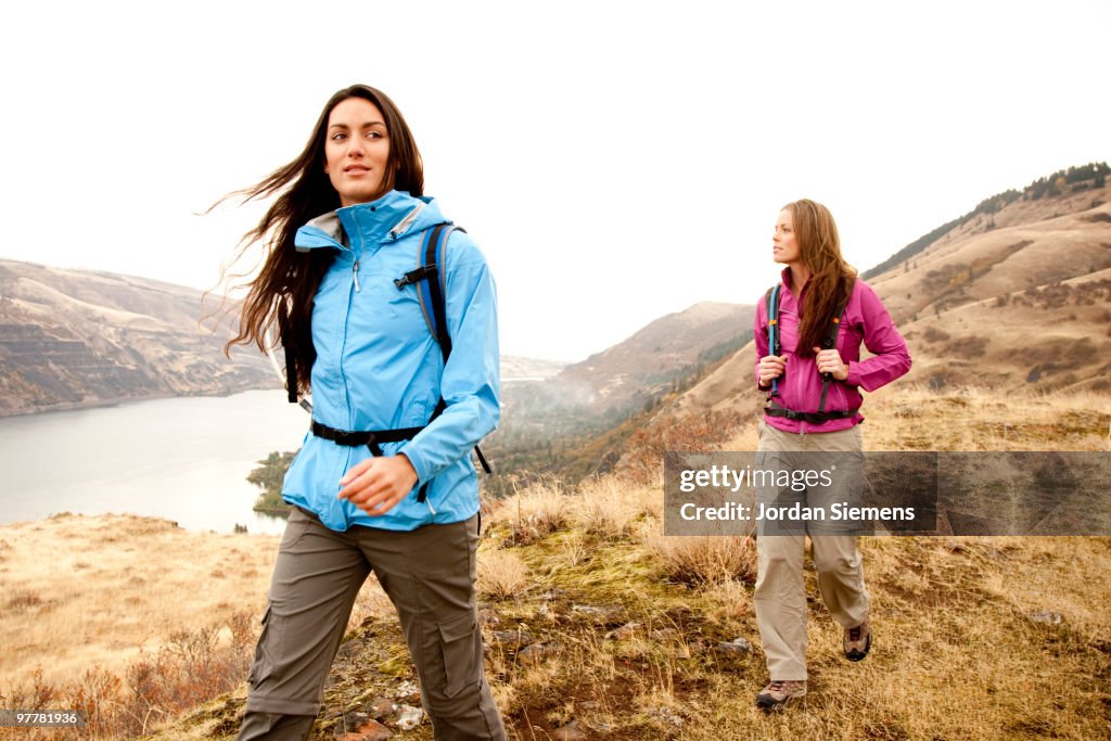 Two females in bright clothes hiking in the Columbia River Gorge, Oregon.