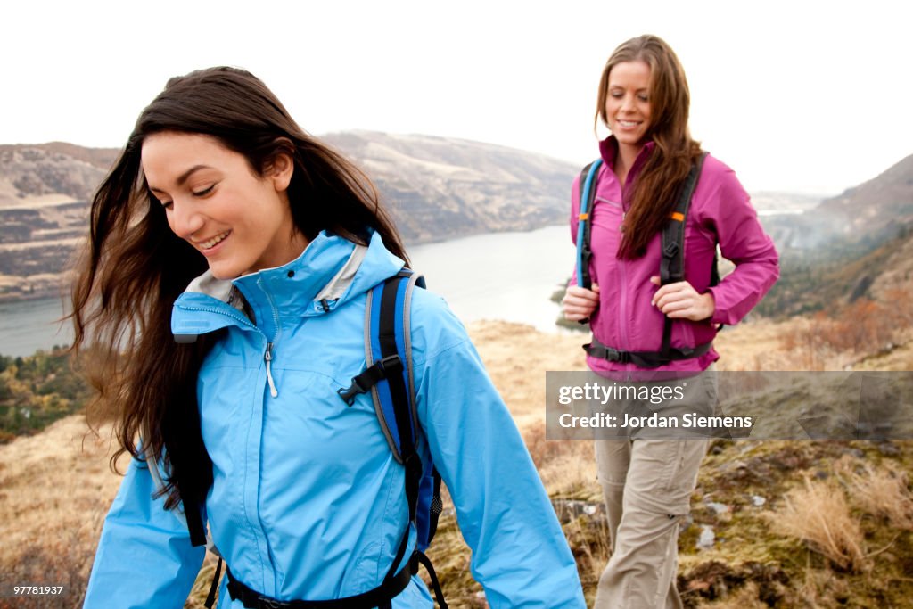 Two females in bright clothes hiking in the Columbia River Gorge, Oregon.