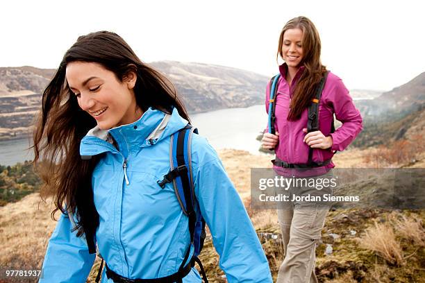 two females  in bright clothes hiking in the columbia river gorge, oregon. - newfriendship stock pictures, royalty-free photos & images