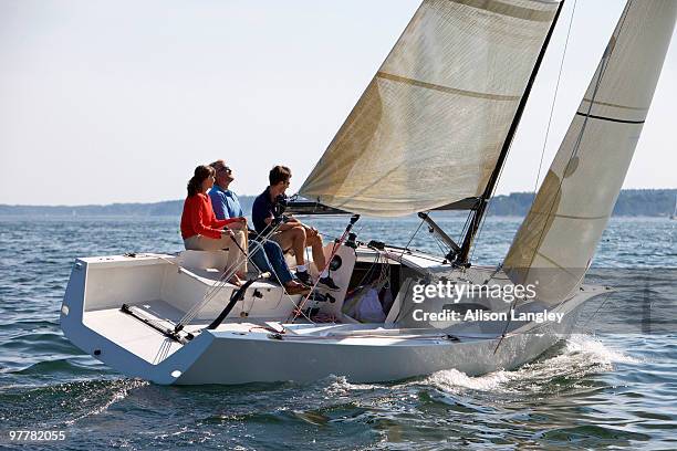 three adults enjoying a sunny day on board a daysailer on casco bay, maine. - casco stockfoto's en -beelden