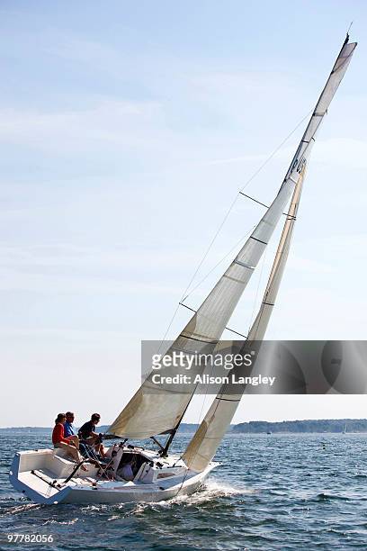 three adults enjoying a sunny day on board a daysailer on casco bay, maine. - casco stockfoto's en -beelden