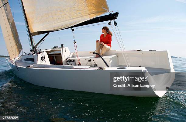 a woman enjoying a sunny day on board a daysailer on casco bay, maine. - casco stockfoto's en -beelden