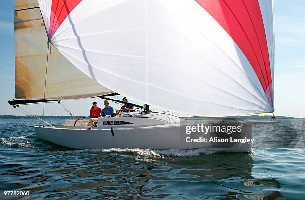 three adults enjoying a sunny day on board a daysailer on casco bay, maine. - casco stockfoto's en -beelden