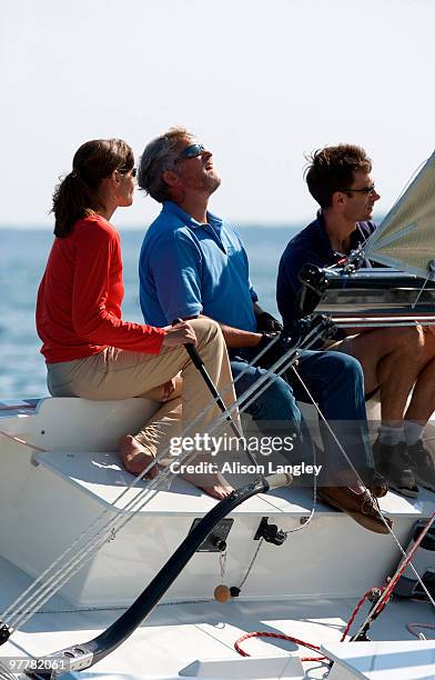 three adults enjoying a sunny day on board a daysailer on casco bay, maine. - casco stockfoto's en -beelden